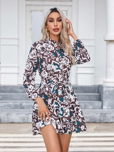 Detail of floral print dress with long lantern sleeves and waist tie in outdoor setting