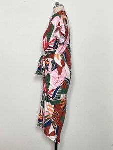 Detail of tropical plant leaf print and tie-waist on a button-down summer dress