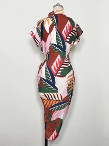Detail of slim fit midi dress with vibrant tropical leaf print and button-down front