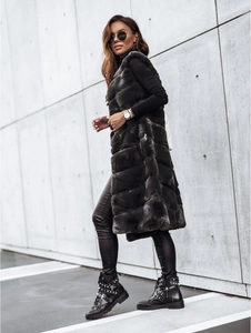Détail du long gilet en fausse fourrure grise avec couches et bottines cloutées