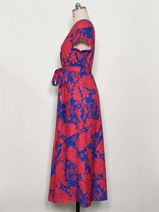 Detail of V-neck floral summer dress with side slit and blue fabric with red flowers