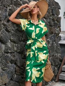 Detail of green floral midi shirt dress with tie waist and button front for summer