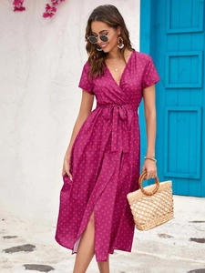 Detail of V-neck wrap dress with red polka dots and tie-waist in magenta color