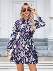 Close-up of floral leaf print and button detail on a navy long sleeve midi dress