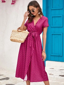 Detail of a magenta wrap dress with red polka dots and a V-neckline in a vacation setting