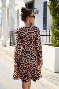 Detailed close-up of leopard print long sleeve dress with waist belt and chiffon texture