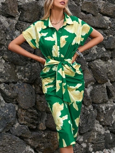 Detail of short sleeve rolled cuffs and floral print on a green summer shirt dress