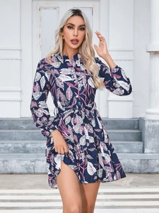 Detail of tropical print dress with button front, waist tie, and navy floral pattern