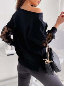Detail of elegant black off-shoulder top featuring vintage floral lace sleeve paneling
