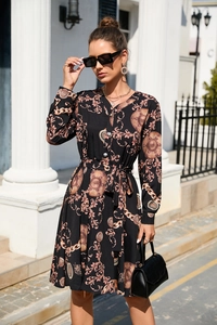 Detailed macro view of baroque print featuring golden chains and coins on a black dress