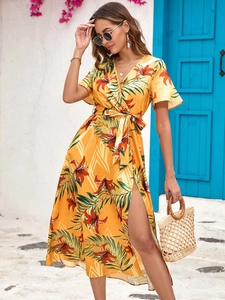 Close-up of tropical floral print and side slit detail on yellow V-neck summer dress