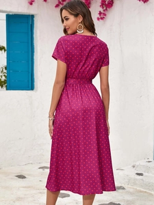 Back view of a summer purple midi dress with red polka dots and waist tie detail