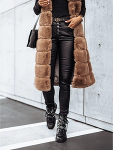 Détail d'un long gilet en fausse fourrure camel avec legging noir et bottines à clous