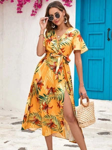 Detail of high side slit on a yellow floral summer dress with tropical lily print