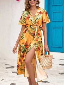 Detail view of yellow tropical floral midi dress with side slit and waist tie detail