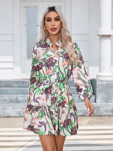 Detail of floral print dress with button-down front, waist tie, and ruffled hem finish