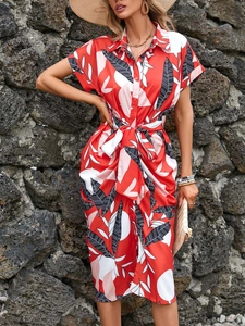 Detail of red tropical leaf print shirt dress with button-front and waist tie-belt