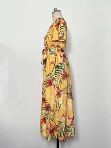 Side view of yellow midi dress featuring red floral print and tropical leaf patterns