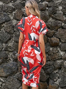 Detail view of red leaf print dress with a cinched waist and sleek satin-like fabric