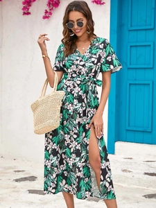 Detail of floral wrap dress featuring a high side slit and tropical leaf print