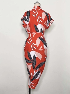Close-up of red slim-fit dress featuring abstract leaf print and button-down collar