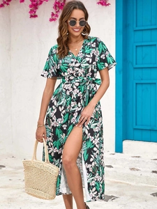 Close-up of tropical palm print midi dress with V-neck wrap design and high leg slit