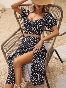 Detail of high-slit long skirt and puff sleeve crop top with white droplet prints
