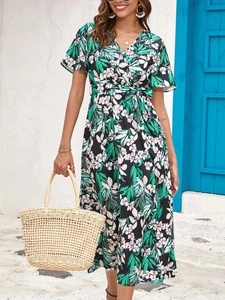 Detail of floral print maxi dress featuring a V-neckline and tie waist on black fabric