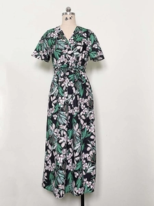 Detail of V-neck wrap dress featuring tropical palm leaf and floral print pattern