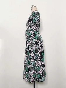 Detail of tropical floral print on black midi dress with waist tie and side slit