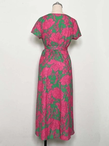 Detailed back view of a green floral maxi dress featuring a matching waist tie and side slit