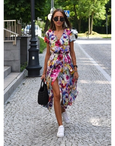 Detail of colorful floral print wrap dress with side slit and waist tie shown on street