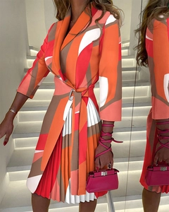 Detail of V-neck printed pleated dress with waist tie and abstract geometric pattern