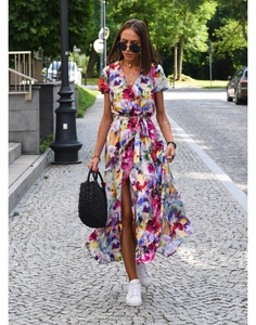 Outdoor street view of a floral printed wrap dress with a V-neck and waist tie design