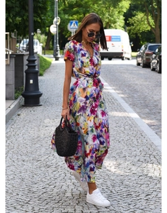 Detail of colorful floral print and adjustable waist tie on a summer V-neck midi dress