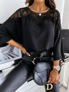 Nahaufnahme der eleganten Spitze und des floralen Ausschnitts an der schwarzen Slim-Fit-Bluse
