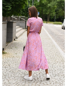 Rear view of a pink floral midi dress with a waist tie and A-line cut on a street