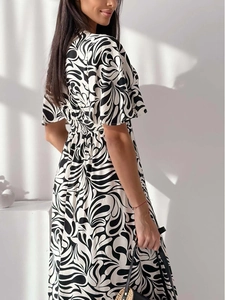 Detail of V-neck waist pleats and monochrome geometric spiral pattern on a short sleeve dress