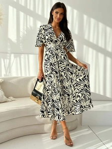 Detail of V-neck maxi dress with abstract black and white print and woven handbag