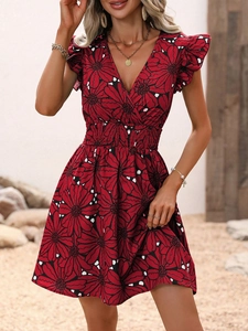 Détail du col en V, manches à volants et taille froncée sur robe rouge fleurie