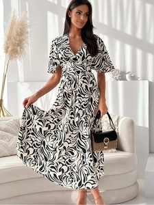 Detail of V-neck printed summer dress showing elegant black and white swirl pattern