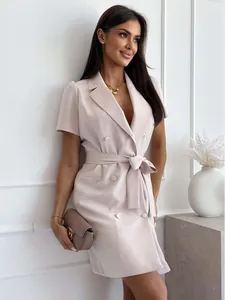 Detail of short sleeve blazer dress showing double-breasted gold buttons and waist tie