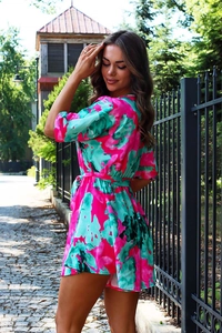 Close-up of vibrant floral print romper with V-neck and matching waist tie detail