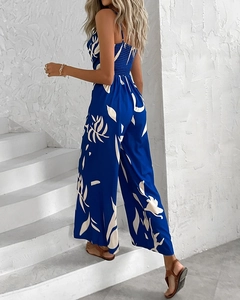 Detail view of tropical leaf print jumpsuit featuring a smocked back and wide-leg design