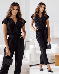 Detail of elegant black V-neck short sleeve jumpsuit with wide waist belt and side pockets