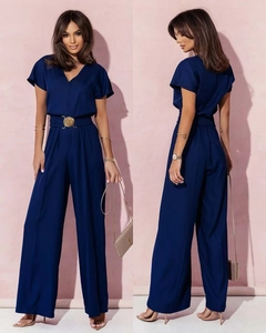 Détail d'une combinaison bleu marine avec col en V, taille haute et boucle dorée