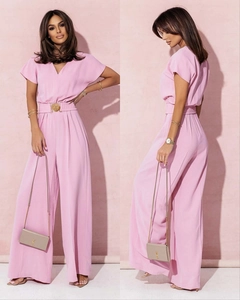 Détail d'une combinaison rose clair à col en V avec ceinture dorée et pantalon large