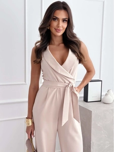 Dettaglio di una tuta beige con scollo a V, cintura in vita e pantaloni larghi