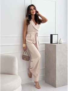 Dettaglio della tuta senza maniche beige con scollo a V, cintura in vita e gamba larga