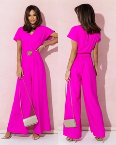 Détail d'une combinaison rose à col en V avec zip invisible au dos et ceinture dorée